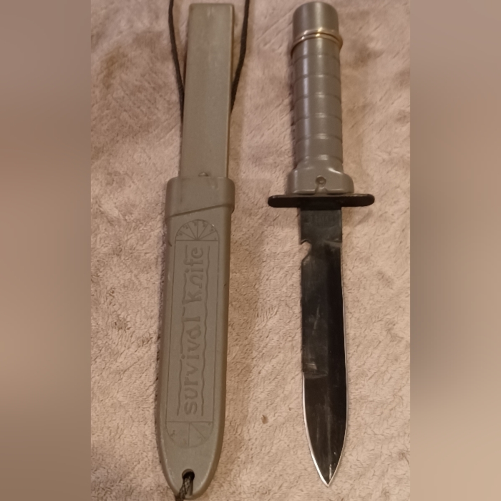 Bayonet style survival knife. Has compass little pack for matches and finger saw